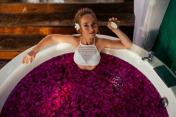 Mulher relaxante em banho com flores tropicais ao ar livre no hotel de luxo — Fotografia de Stock