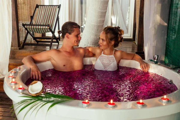 Dia dos Namorados jovem casal deitado em jacuzzi banheiro romântico em lua de mel — Fotografia de Stock