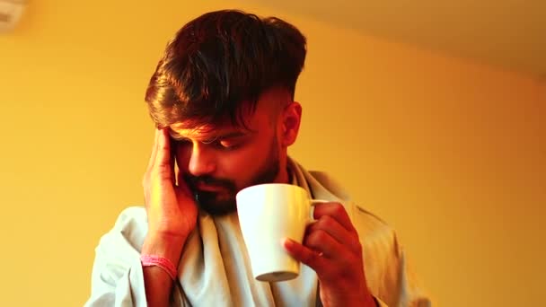Tengo fiebre. Un indio bebiendo una taza de té caliente en casa. — Vídeo de stock