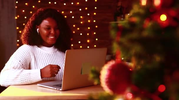 Braziliaanse vrouw verbinding met haar familie online in de avondkamer met slingers verlichting backgroind — Stockvideo