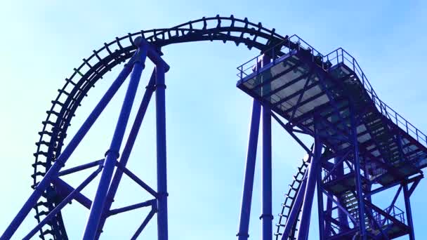 Les gens dans plusieurs voitures montent sur montagnes russes dans le parc d'attractions fond de ciel — Video