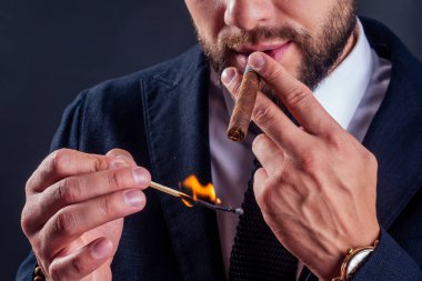 Siyah arka planda purosu olan çekici bir iş adamının portresi.