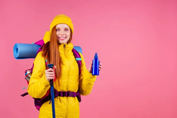 Szczęśliwa kobieta gotowa do podróży w góry w nowej żółtej kurtce — Zdjęcie stockowe