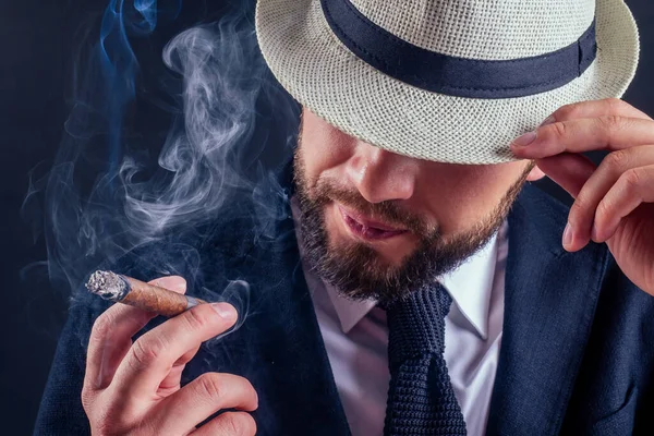 Porträtt av en attraktiv affärsman med en cigarr i svart bakgrund studio — Stockfoto