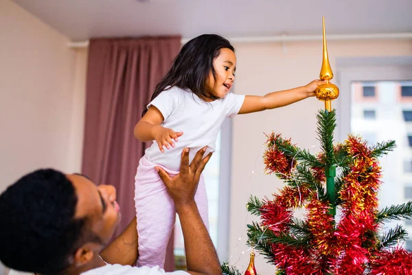 Feliz mezcla de raza padre y alegre hermosa hija decoración interior en sala de estar — Foto de Stock