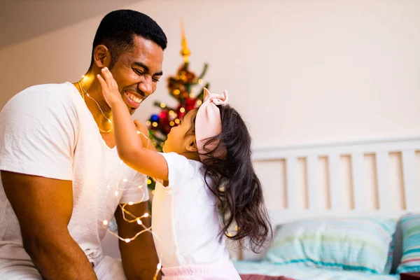 Feliz padre de raza mixta y hermoso niño en la feliz mañana de x-mas en el dormitorio — Foto de Stock