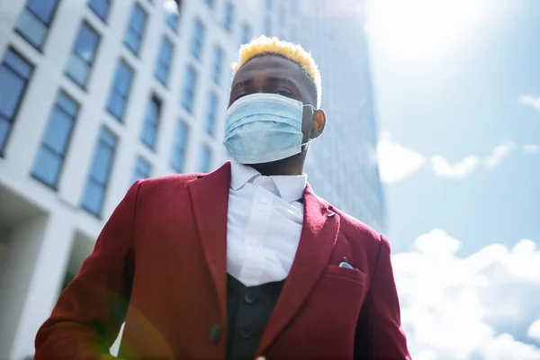 Mulatte lateinischer Geschäftsmann in Marsala-Jacke setzt Maske auf, um Luftverschmutzung im Freien zu verhindern — Stockfoto