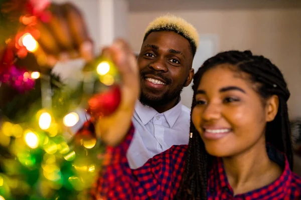 Multicultural family decorating christmas tree with ball and garland — Stock Photo, Image
