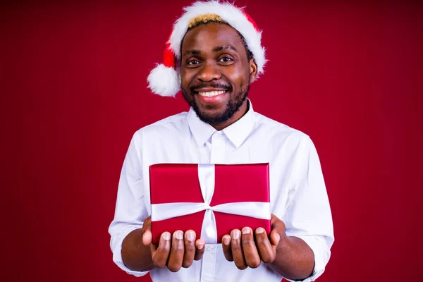 Latino hispânico homem vestindo chapéu de santas no estúdio vermelho fundo — Fotografia de Stock