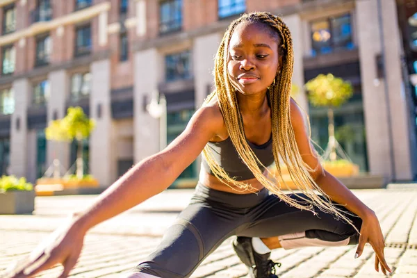 Lateinamerikanisches Mädchen mit langen gelben Dreadlocks und Zöpfen beim Outdoor-Training in den Straßen der Stadt — Stockfoto