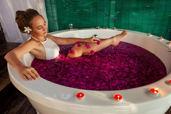 Mujer relajante en baño redondo al aire libre con flores tropicales, cuidado orgánico de la piel, hotel spa de lujo San Valentín solo luna de miel — Foto de Stock