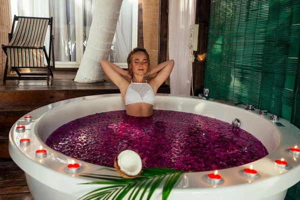 Mujer relajante en baño con flores tropicales al aire libre en hotel de lujo — Foto de Stock