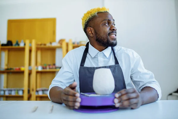 Retrato de homem latino-hispânico brasileiro positivo fazendo panela de cerâmica na roda de cerâmica — Fotografia de Stock