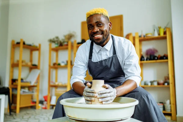 Retrato de homem latino-hispânico brasileiro positivo fazendo panela de cerâmica na roda de cerâmica — Fotografia de Stock