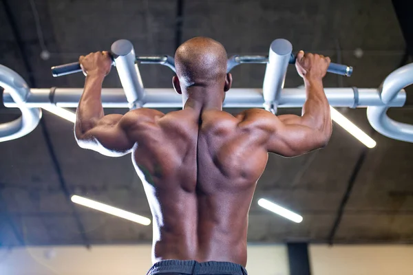Pelatih mengangkat beban di atas latar belakang gelap di gym baru — Stok Foto