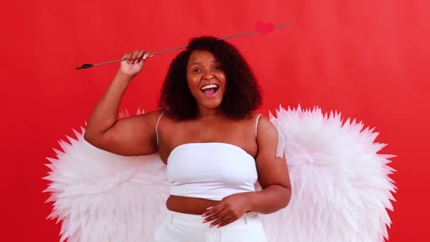 Afrika latinska cupid kvinna i wtite topp bh hålla båge och pil i röd studio Den 14 februari Alla hjärtans dag — Stockvideo