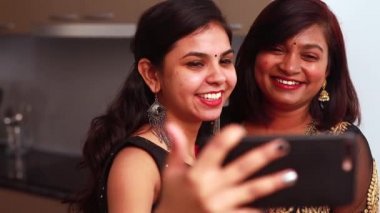 İki güzel Hintli kadın, Diwali 'de geleneksel kıyafetler giyerek aile içi video görüşmeleri yapıyor. Ya da başka bir festival kutlaması.