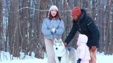 Üçlü grup halinde melez bir aile yeni yıl tatillerini köpekleri ile parkta geçiriyorlar.