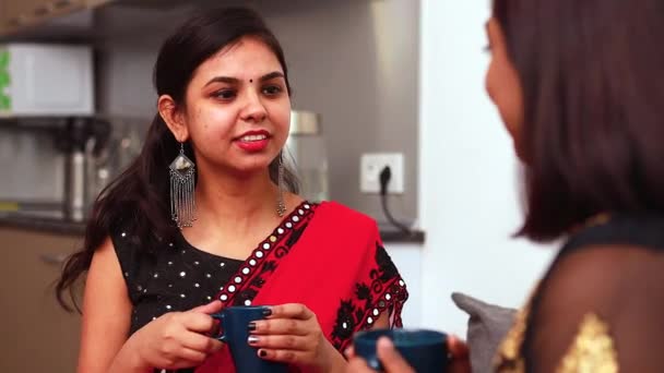 Duas melhores amigas bebendo chá ou chá de masala juntas em casa em saree — Vídeo de Stock