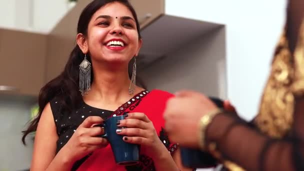 Twee vrouwelijke beste vrienden drinken thee of masala thee samen thuis in saree — Stockvideo