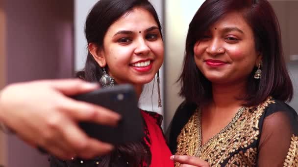 아름다운 두 명의 인도 여성이 온라인 비디오 통화를 하며 디 왈리를 위한 전통적 인 전통 의상을 입고 있거나 다른 축제를 기념하고 있다. — 비디오