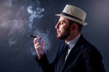 Siyah arka planda purosu olan çekici bir iş adamının portresi.