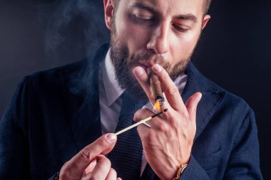 Siyah arka planda purosu olan çekici bir iş adamının portresi.