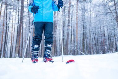 Mavi ceketli Afro-Amerikan adam Donmuş Orman 'da kayak yapıyor.