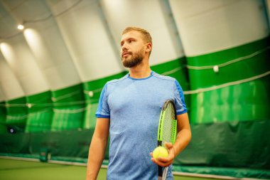 Eğitmen ya da koç içeride tenis oynamayı öğretiyor.