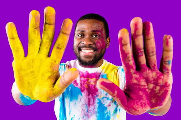 Afro-Amerikalı adam Holi festivalini Violet stüdyosunda kutluyor. — Stok fotoğraf