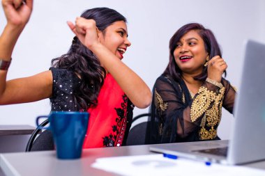 İki Hintli üniversite ofiste tablet bilgisayar kullanarak fikirleri tartışıyor.