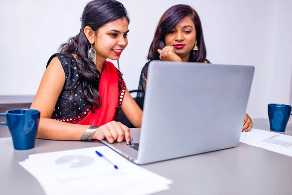Geleneksel sarili iki güzel kadın ofiste ya da kafede çalışıyor.