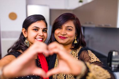 Mutlu karışık ırk dostları evdeki oturma odasında birbirlerine sarılıyorlar.