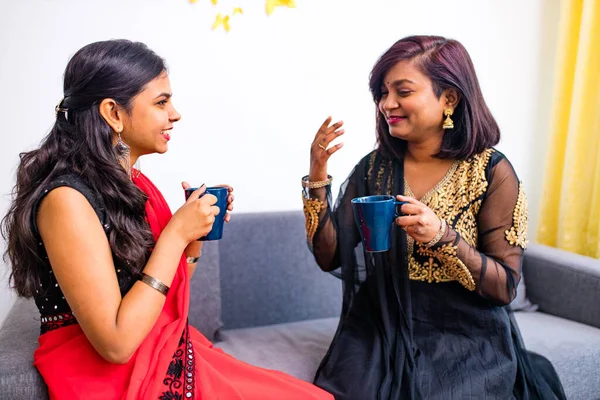Две счастливые молодые подруги с кофейными чашками в гостиной дома — стоковое фото