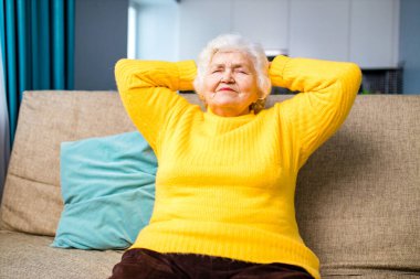 Olgun kadın rüya görüyor, güzel geleceği düşünüyor oturma odasında kanepede oturuyor.