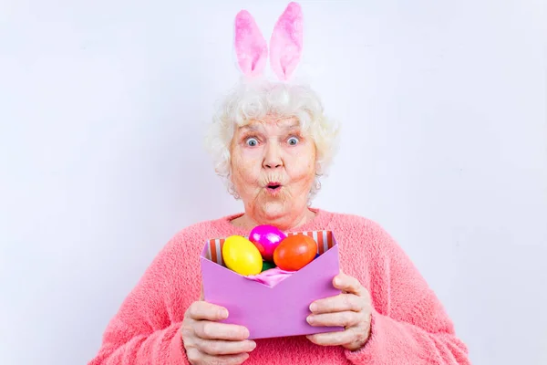 Feliz mujer de 80 años con orejas de conejo y huevos de Pascua —  Fotos de Stock