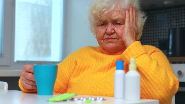 Ill vecchia donna che prende una pillola da un distributore di pillole nella sua casa — Video Stock