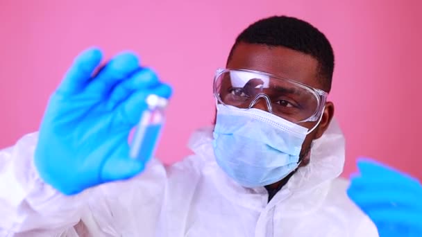Концепция вакцинации Corona SARS-CoV-2: человек на розовом фоне стены студии — стоковое видео