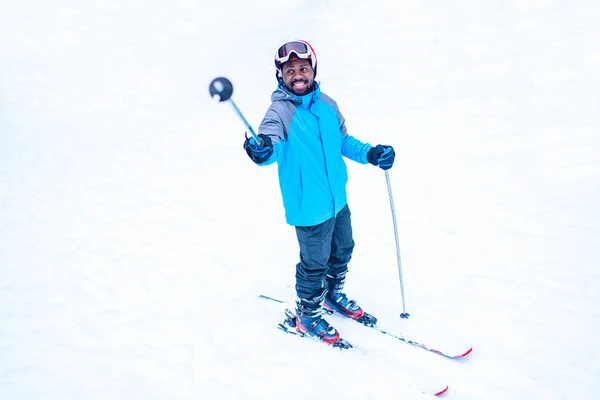 Afro americano uomo in giacca blu correre sci all'aperto nella foresta congelare — Foto Stock