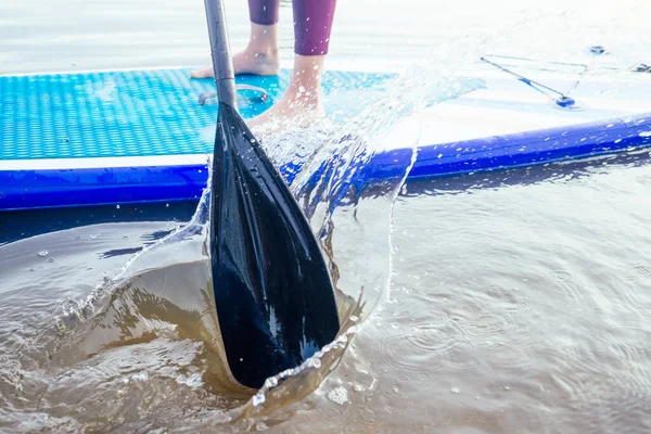 Durgun bir göl kıyısında ayakta durun, bacaklarınızı yakın tutun ve su sıçratın.