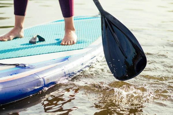 Wstań paddle boarding na spokojnym jeziorze morskim, zbliżenie nóg i wody splash — Zdjęcie stockowe
