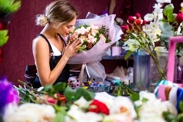 Florist woman creates flower bouquet of mixed flowers for delivery to client — Stock Photo, Image