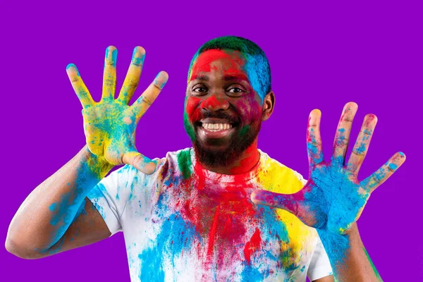 Латино-бразильский мужчина в белой хлопчатобумажной футболке с красочной краской лица смеющейся студии — стоковое фото