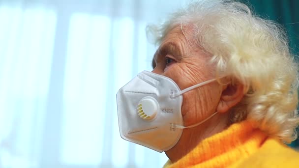 Femme âgée dans sa maison dans le salon portant un masque médical — Video