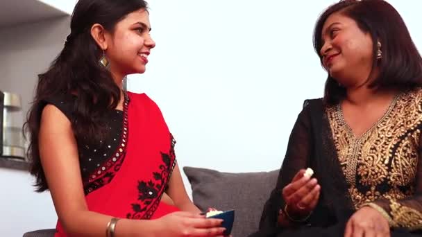 Indické ženy jedí popcorn a mluví, zatímco sedí v obývacím pokoji — Stock video