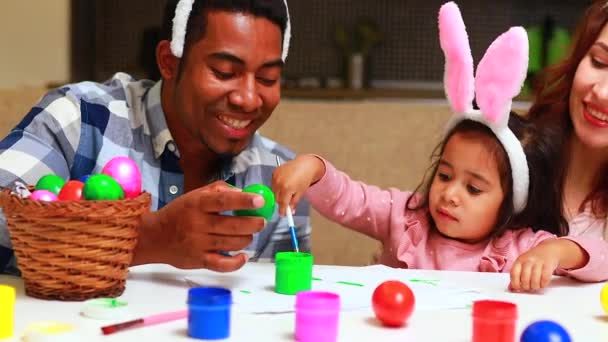 Glückliche Mischlingsfamilie feiert Ostern, bemalt Eier mit Pinsel lächelnd und lachend — Stockvideo
