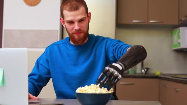 Young man watching a movie in laptop and eating pop corn at home — Stock Video