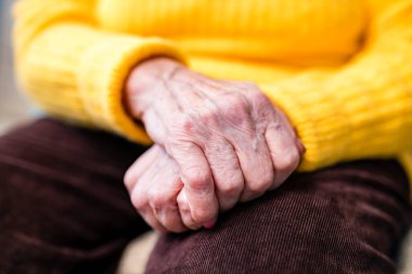 Yaşlı kadın elleri buruşuk. Diz çök.