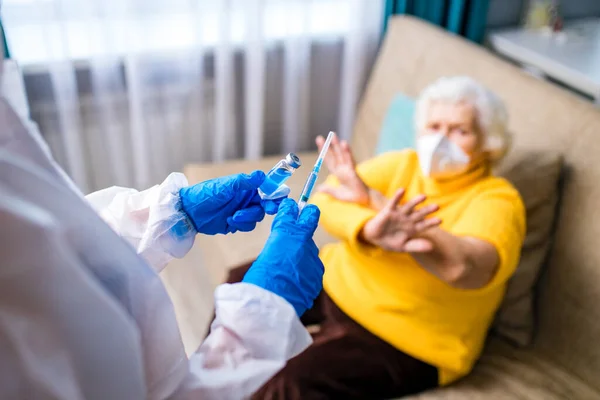 Stará žena odmítly z covid-19 vakcinace v obývacím pokoji u ní doma — Stock fotografie