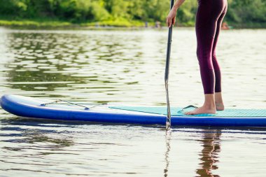 Durgun bir göl kıyısında ayakta durun, bacaklarınızı yakın tutun ve su sıçratın.